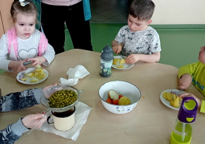 Dzieci kroją warzywa do sałatki.